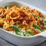 Cheesy green bean casserole with golden crispy topping served hot
