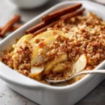 Gluten-free apple crisp baked with almond flour and oats, served warm with ice cream.