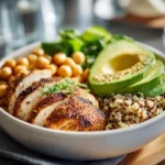 High protein chicken quinoa salad bowl with avocado and veggies.