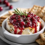 Gooey baked brie topped with fig jam and crunchy pecans, served warm with crackers.