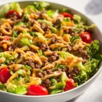 Delicious Big Mac Salad topped with special sauce and fresh vegetables