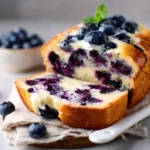 Delicious slice of Blueberry Cream Cheese Bread garnished with fresh blueberries