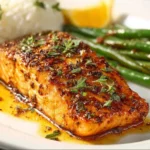 Cajun Honey Butter Salmon 2 Delicious Cajun Honey Butter Salmon served on a plate with herbs and lemon.