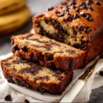 Sliced chocolate chip banana bread on a wooden board