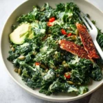 Kale salad topped with creamy caper dressing and fresh ingredients