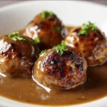 Savory meatballs served in a thick brown gravy dish