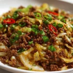 Plate of Mongolian ground beef and cabbage topped with green onions