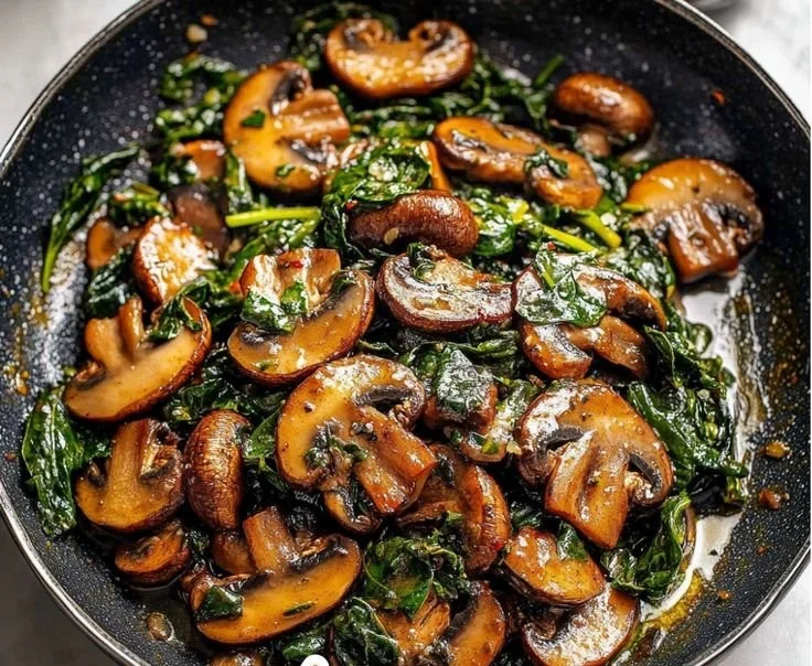 Delicious sautéed spinach with mushrooms in a pan
