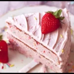 A slice of vibrant Strawberry Funfetti Cake with colorful sprinkles and fresh strawberries