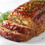 Delicious stuffed meatloaf sliced and served with vegetables