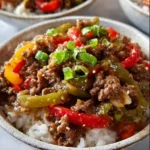 Delicious beef and pepper rice bowls served with colorful peppers and rice.