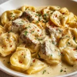 Cheesesteak tortellini in creamy provolone sauce garnished with herbs