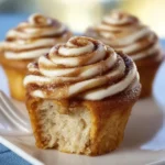 Delicious homemade cinnamon roll cupcakes with frosting and cinnamon topping.