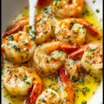 Garlic Butter Shrimp Scampi 3 Garlic butter shrimp scampi served with fresh herbs and lemon on a plate.