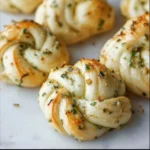 Freshly baked homemade garlic knots topped with parsley and garlic butter.