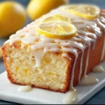 Homemade Starbucks copycat lemon loaf with a glazed top and fresh lemon slices
