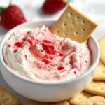 Strawberry Cheesecake Dip 3 Creamy strawberry cheesecake dip served in a bowl with fresh strawberries on the side.