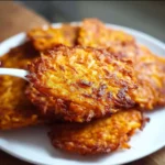 Crispy sweet potato fritters served with dipping sauce on a plate