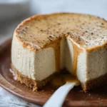 Slice of vanilla bean brown butter cheesecake topped with caramel sauce