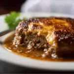 Delicious Amish Hamburger Steak Bake served in a dish with vegetables and gravy.