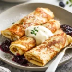 Delicious homemade blintzes filled with sweet cheese and topped with fruit.