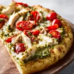 Chicken Pesto Pizza 3 Delicious Chicken Pesto Pizza topped with chicken, pesto sauce, and fresh ingredients.