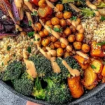 Delicious roasted veggie chickpea bowls garnished with fresh herbs and spices.