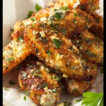 Delicious garlic parmesan wings garnished with herbs and spices.