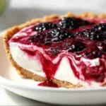 Slice of delicious Blackberry Lemonade Pie topped with fresh blackberries and a lemon slice.