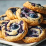 Blueberry Cheesecake Cookies 3 Blueberry cheesecake cookies on a plate, showcasing their delicious texture and color