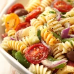 Bowl of Classic Pasta Salad with fresh vegetables and dressing