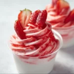 Delicious Frozen Strawberry Dole Whip served in a cup with fresh strawberries.