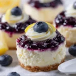 Healthy mini lemon blueberry cheesecakes on a plate with fresh blueberries