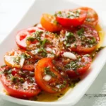 Fresh marinated tomatoes in a bowl with herbs and spices