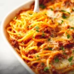 Delicious Million Dollar Spaghetti topped with cheese and herbs.