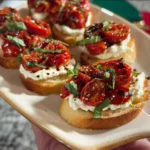 Ricotta crostini topped with roasted tomatoes on a serving platter