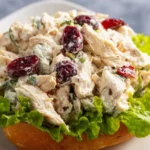 A bowl of the best chicken salad topped with fresh herbs and vegetables