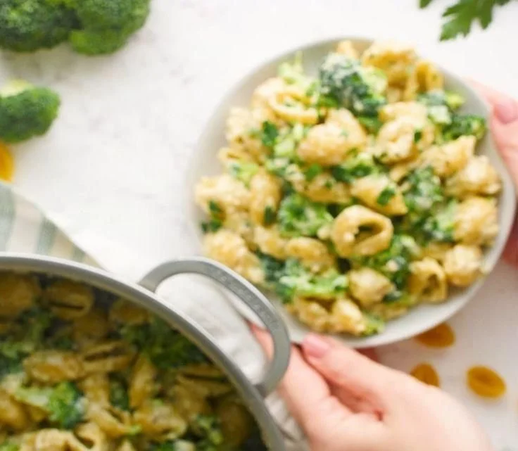 A vibrant plate of Broccoli Pasta garnished with fresh herbs and Parmesan cheese