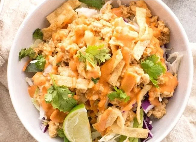 Bowl of chicken wonton tacos topped with fresh ingredients