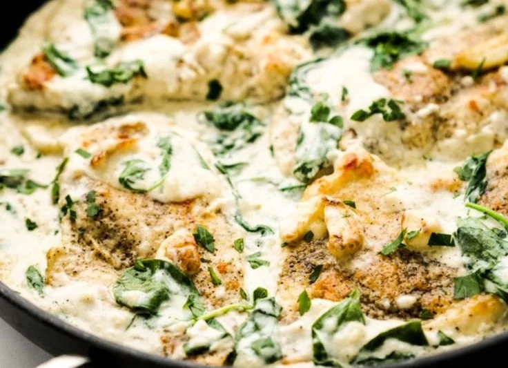 Creamy spinach garlic chicken served on a plate with herbs