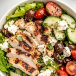 Fresh Greek Salad with Chicken featuring tomatoes, cucumbers, and feta cheese.