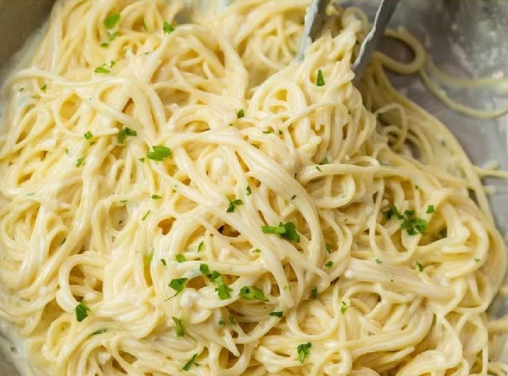 Delicious Garlic Parmesan Pasta with creamy sauce and cheese garnished with herbs.