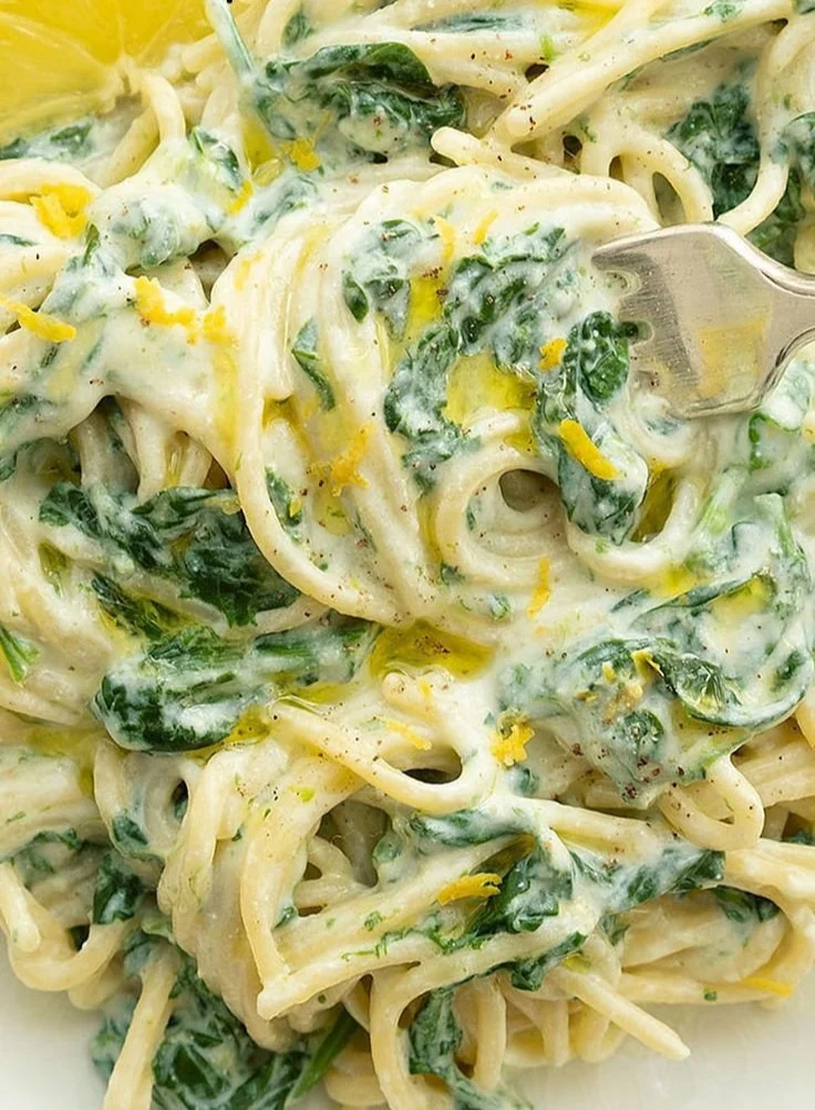 Lemon ricotta pasta with fresh spinach, garnished and ready to serve.