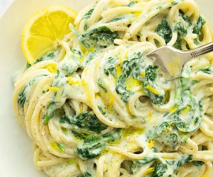 Lemon ricotta pasta with fresh spinach served in a bowl