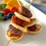 Mini pancake and sausage skewers arranged on a platter