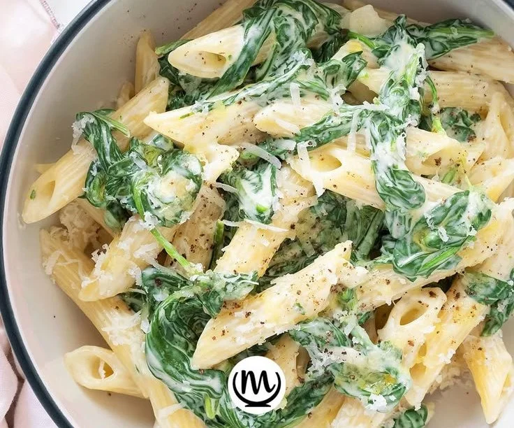 Bowl of simple pasta with fresh spinach and olive oil
