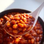 Southern Baked Beans 3 Delicious Southern baked beans served in a bowl with a rustic background.