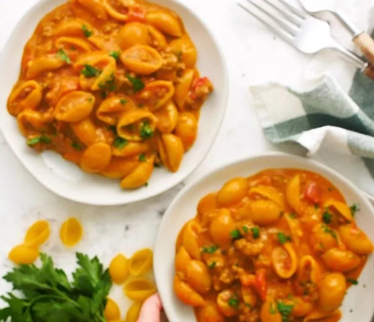 A bowl of tasty Taco Pasta topped with cheese and cilantro.