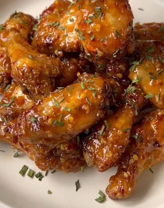 Plate of tasty wings with dipping sauces on a wooden table