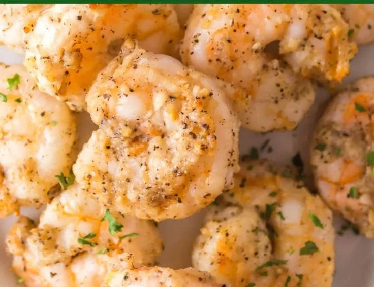 Air fryer garlic parmesan shrimp served on a plate with herbs